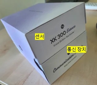 XK300 에센스 제품 박스, 센서와 통신 장치 라벨이 붙어 있는 모습